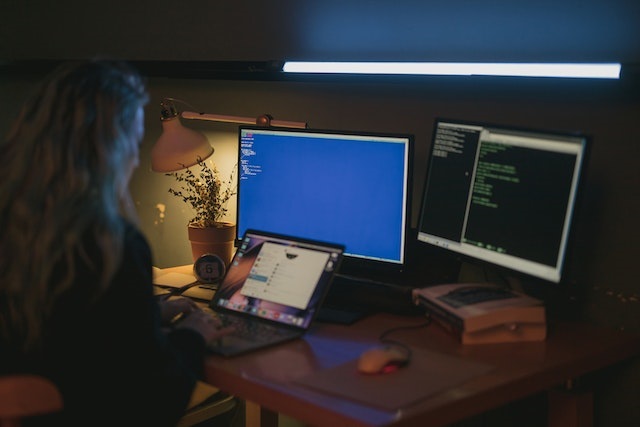 woman on a computer with multiple screens